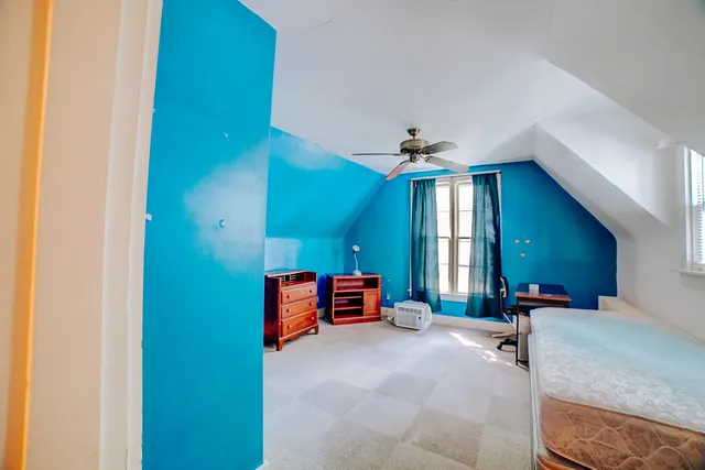 a spacious bedroom with a bed and a chandelier