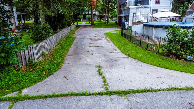 a front view of a house with a yard and potted plants
