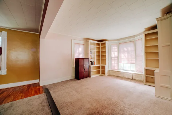 an empty room with a fireplace and cabinet