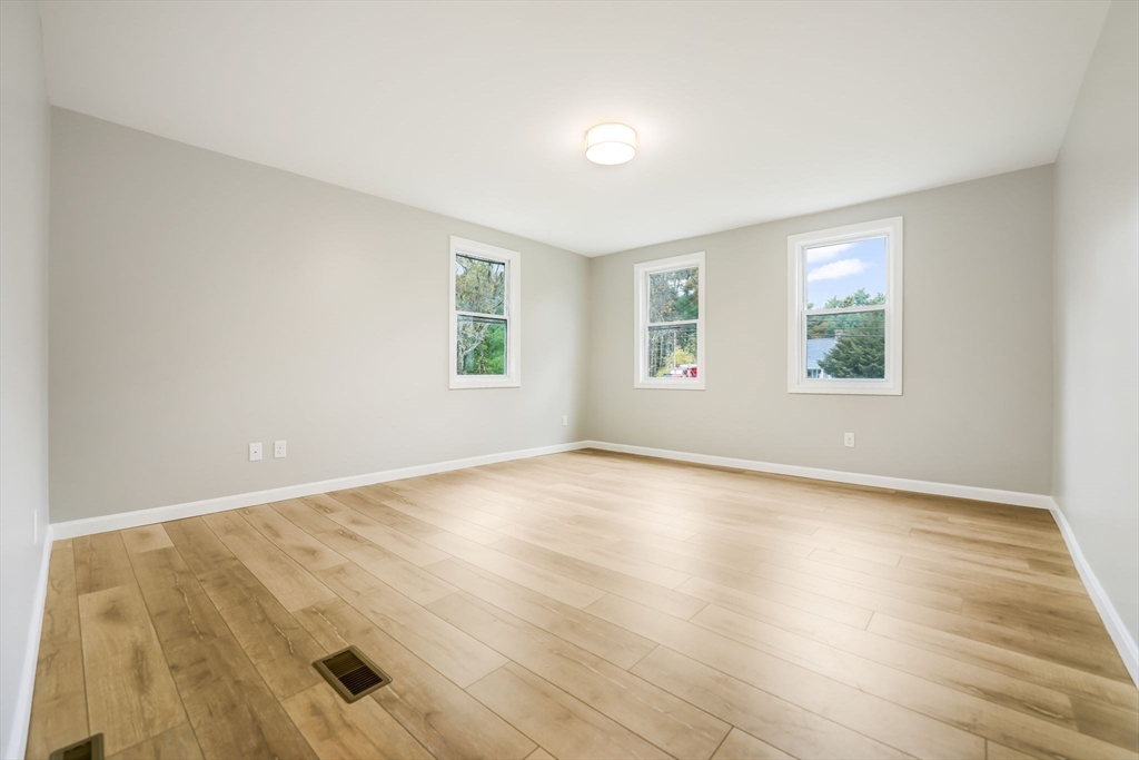 599 Quanapoag Road Dartmouth, MA 02747 - Photo 20 of 32 an empty room with wooden floor and windows