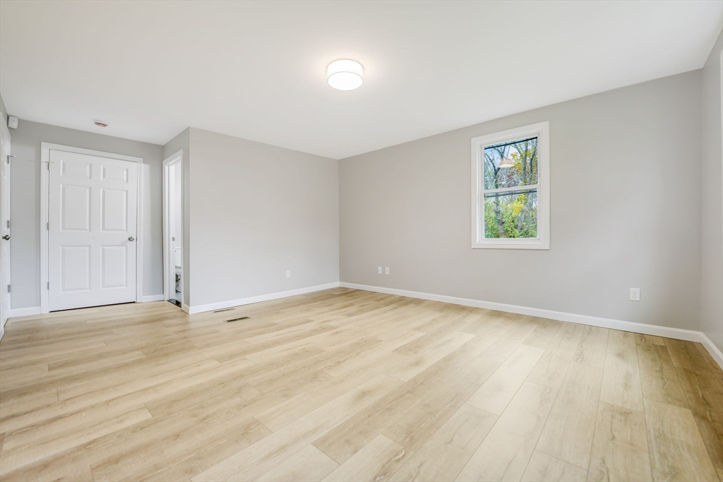 599 Quanapoag Road Dartmouth, MA 02747 - Photo 21 of 32 a view of an empty room with wooden floor and a window