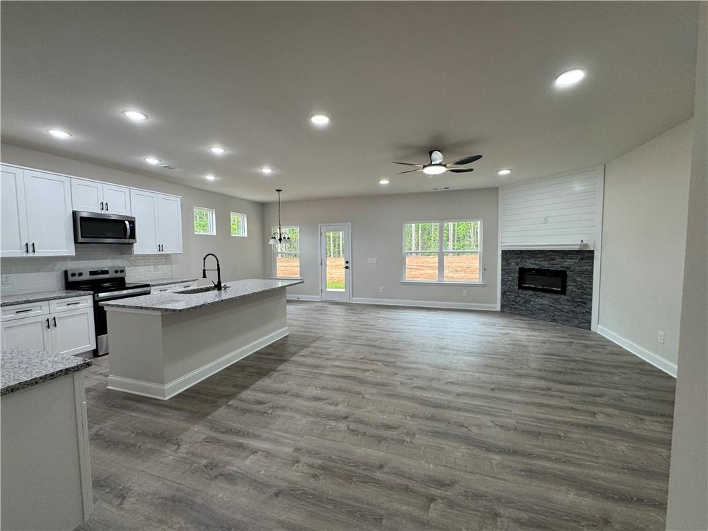 2113 North Hicks Road Toccoa, GA 30577 - Photo 4 of 28 a large kitchen with kitchen island a sink dishwasher a stove and a refrigerator with wooden floor