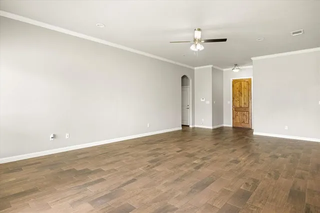 an empty room with a ceiling fan and window