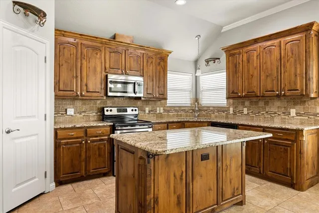 a kitchen with stainless steel appliances granite countertop a stove sink microwave and cabinets