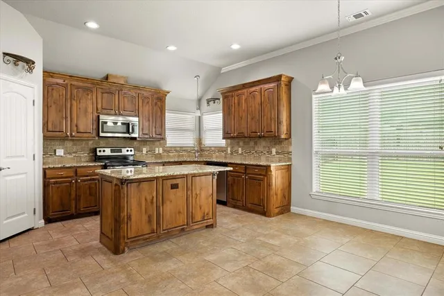 a kitchen with stainless steel appliances granite countertop a stove sink and microwave