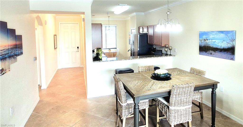 9566 Trevi Court, Unit 4943 Naples, FL 34113 - Photo 12 of 47 a view of a dining room with furniture and a chandelier