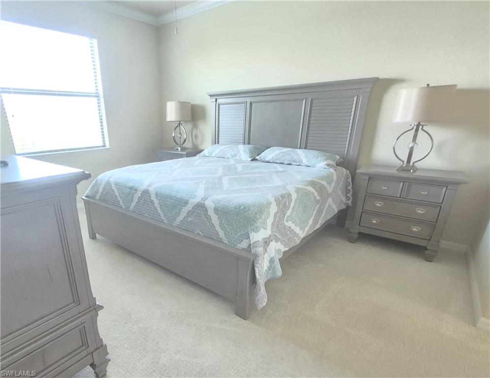 9566 Trevi Court, Unit 4943 Naples, FL 34113 - Photo 18 of 47 a bed sitting in a bedroom next to a window