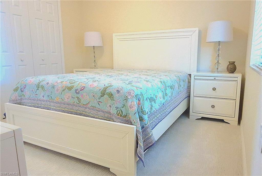9566 Trevi Court, Unit 4943 Naples, FL 34113 - Photo 19 of 47 a bedroom with a bed and a lamp on dresser