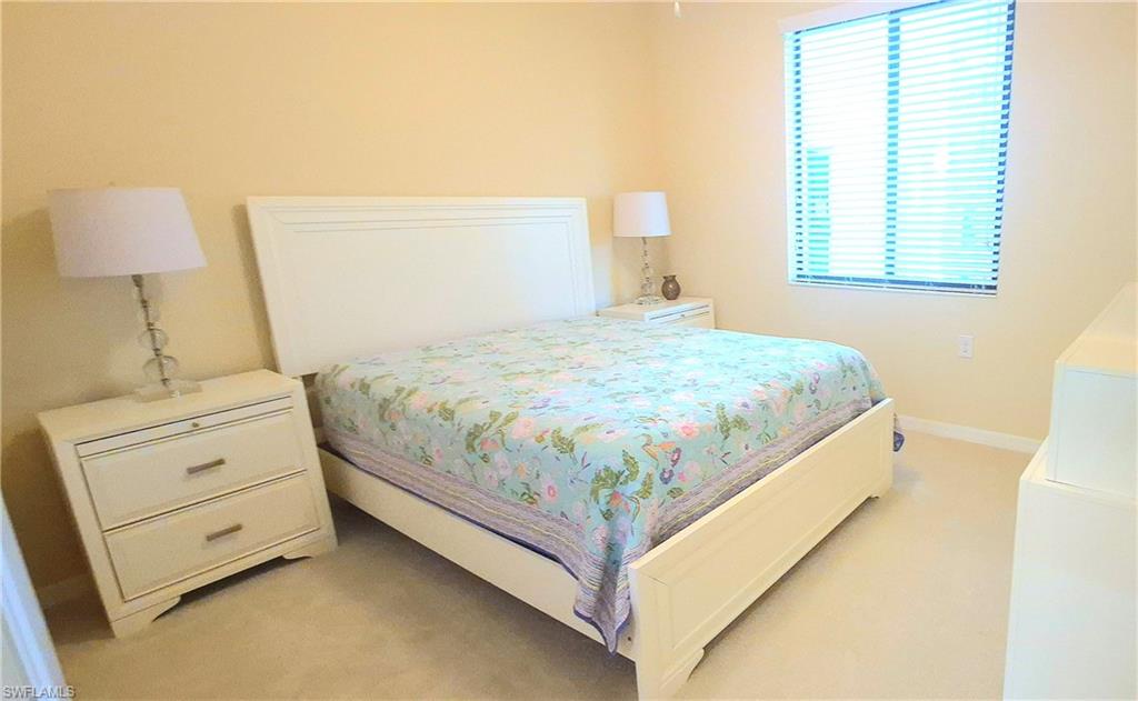 9566 Trevi Court, Unit 4943 Naples, FL 34113 - Photo 20 of 47 a bed sitting in a bedroom next to a window