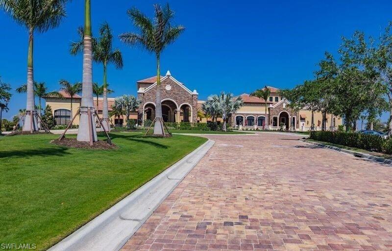 9566 Trevi Court, Unit 4943 Naples, FL 34113 - Photo 25 of 47 a front view of a house with a yard and palm trees