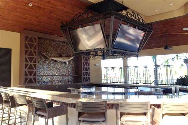 9566 Trevi Court, Unit 4943 Naples, FL 34113 - Photo 26 of 33 a kitchen with a stove and a microwave