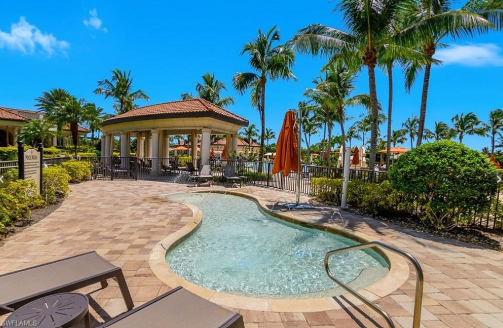 9566 Trevi Court, Unit 4943 Naples, FL 34113 - Photo 36 of 47 a swimming pool with outdoor seating yard and palm trees