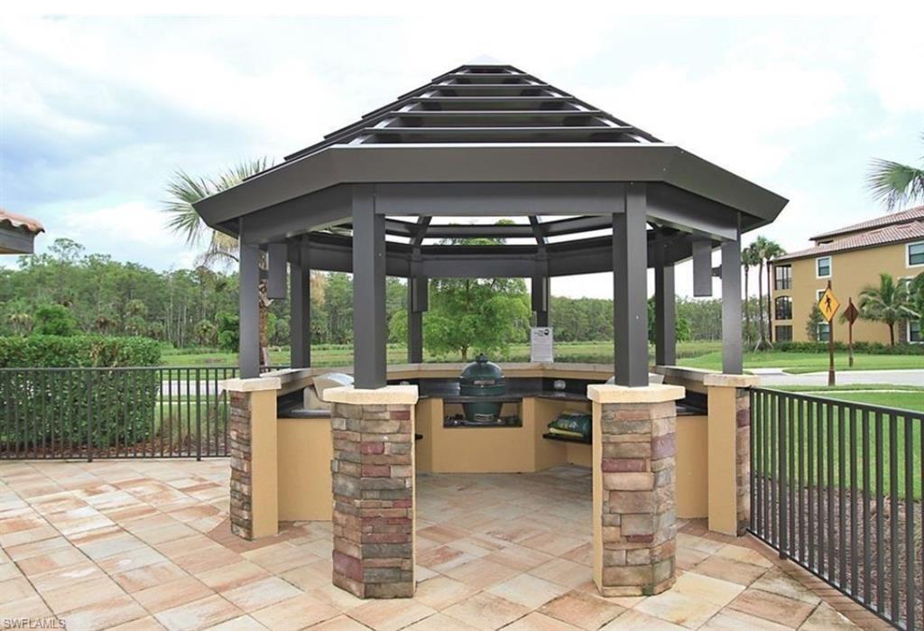 9566 Trevi Court, Unit 4943 Naples, FL 34113 - Photo 40 of 47 a view of a patio with a table chairs and a porch