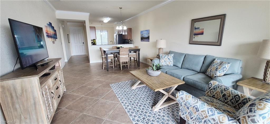 9566 Trevi Court, Unit 4943 Naples, FL 34113 - Photo 9 of 47 a living room with furniture and a flat screen tv
