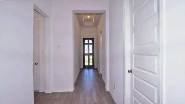 a view of a hallway with wooden floor