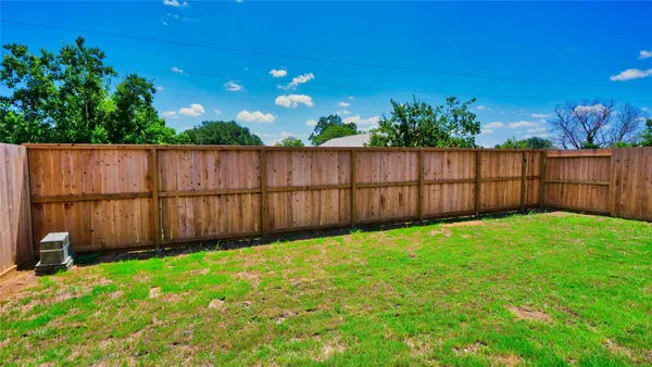 a view of a backyard with wooden fence