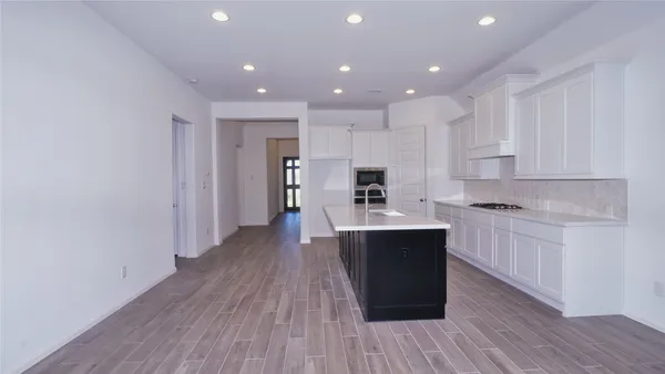 a kitchen with wooden floors and wooden cabinets