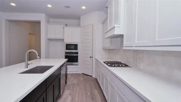 a kitchen with stainless steel appliances granite countertop a sink stove and cabinets