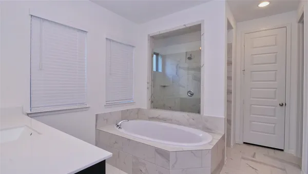 a bathroom with a tub shower and a sink