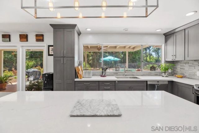 a kitchen with kitchen island a counter top space a sink and stainless steel appliances