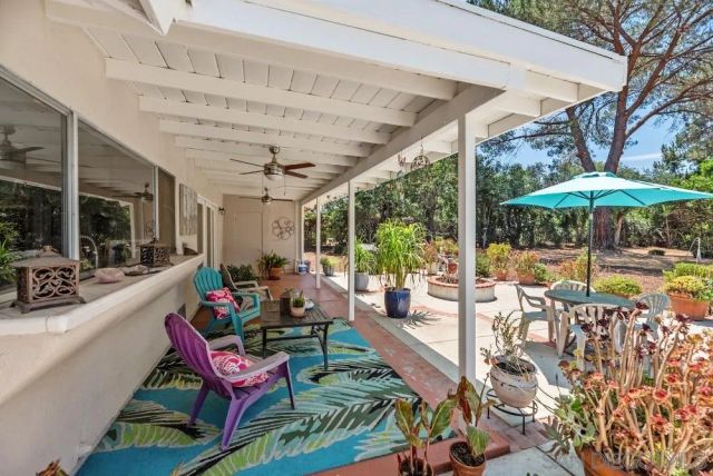 a patio with patio area table and chairs under an umbrella