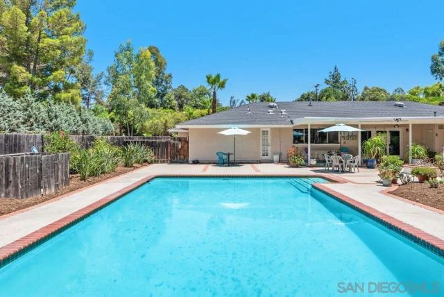 a view of a house with swimming pool and sitting area
