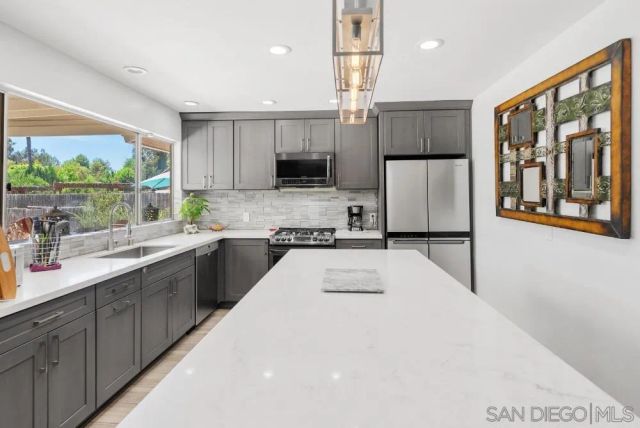 a kitchen with a refrigerator a sink and a stove top oven