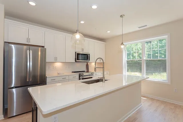 a kitchen with stainless steel appliances a refrigerator sink and microwave