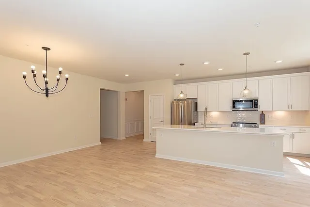 a view of kitchen with stainless steel appliances refrigerator stove microwave and cabinets