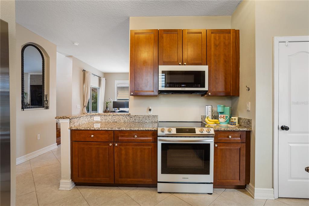 6911 Beargrass Road Harmony, FL 34773 - Photo 14 of 60 a kitchen with a stove and a microwave