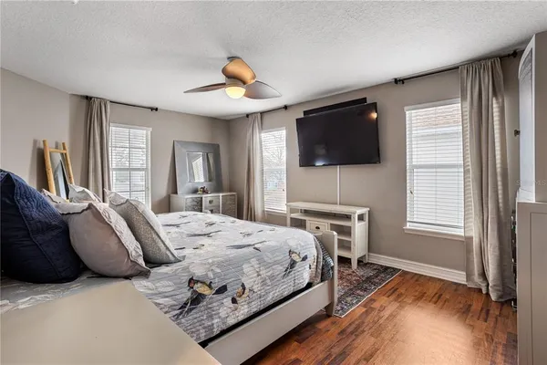 a bed sitting in a bedroom next to a window with pc on the table