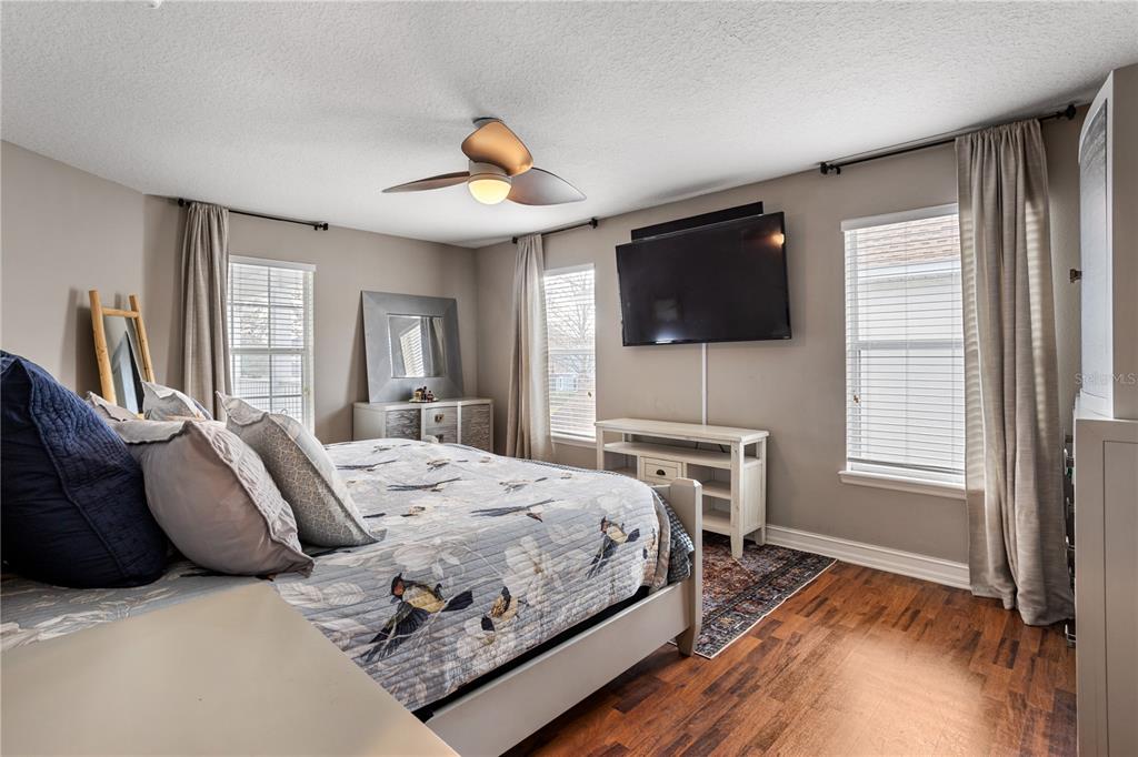 6911 Beargrass Road Harmony, FL 34773 - Photo 15 of 60 a bedroom with a bed and a flat screen tv