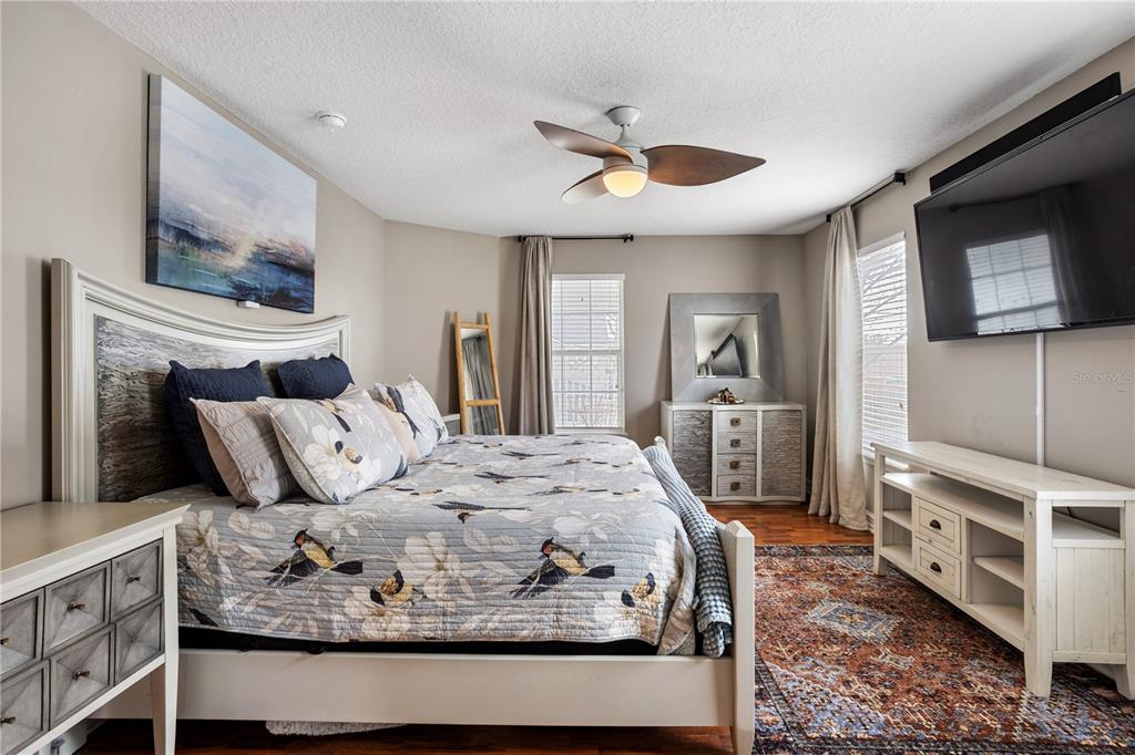 6911 Beargrass Road Harmony, FL 34773 - Photo 16 of 60 a bed sitting in a bedroom next to a window with pc on the table