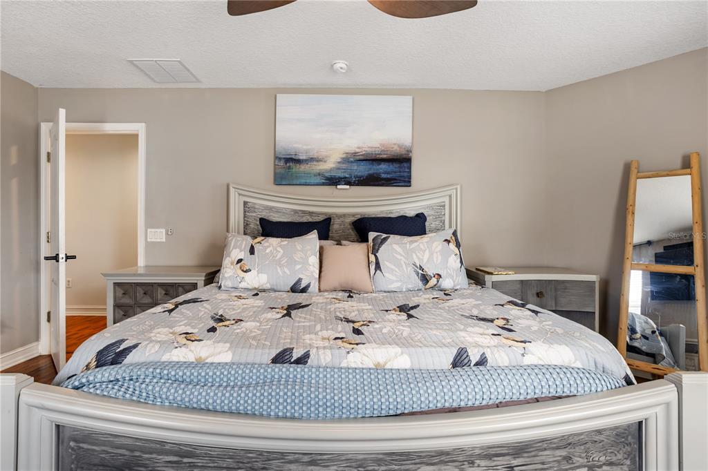 6911 Beargrass Road Harmony, FL 34773 - Photo 21 of 60 a bedroom with a large bed and a flat screen tv