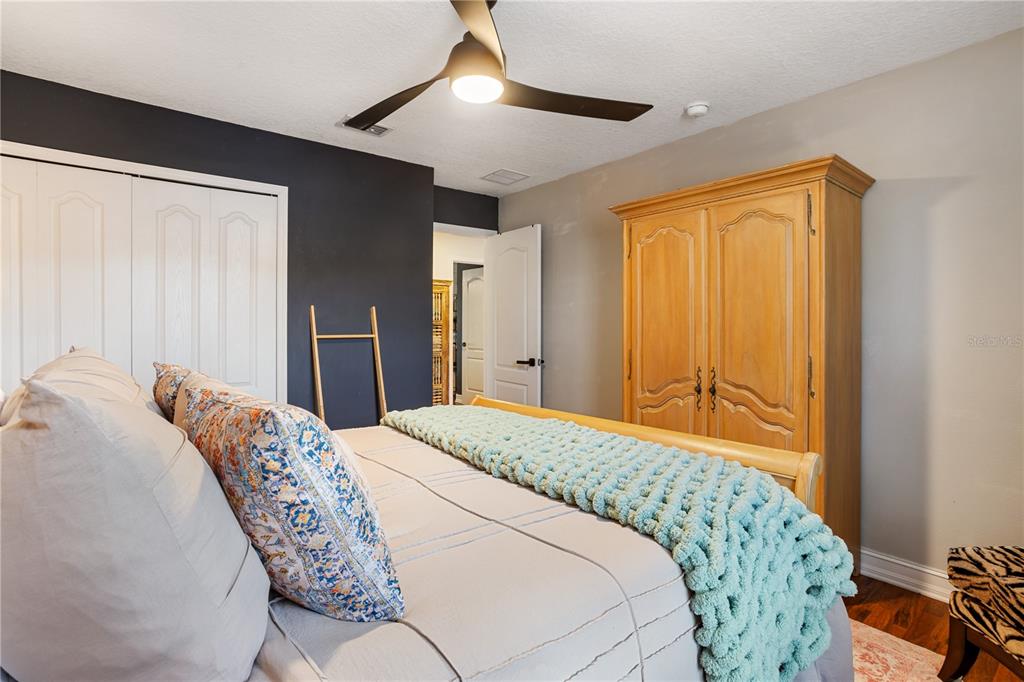 6911 Beargrass Road Harmony, FL 34773 - Photo 26 of 60 a bedroom with a bed and a chandelier