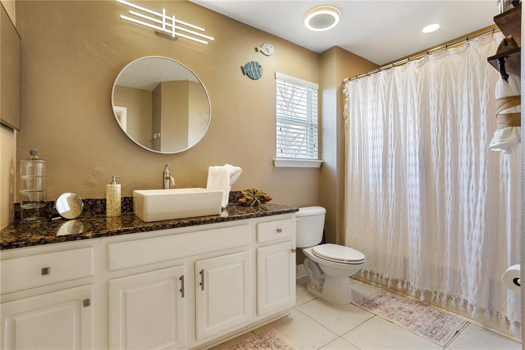 6911 Beargrass Road Harmony, FL 34773 - Photo 29 of 60 a bathroom with a toilet a sink and a mirror