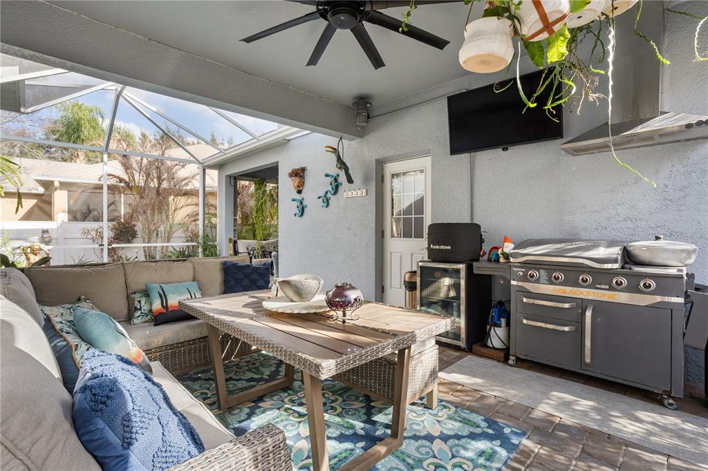 6911 Beargrass Road Harmony, FL 34773 - Photo 32 of 60 a kitchen with stainless steel appliances kitchen island granite countertop a table chairs in it and wooden floor
