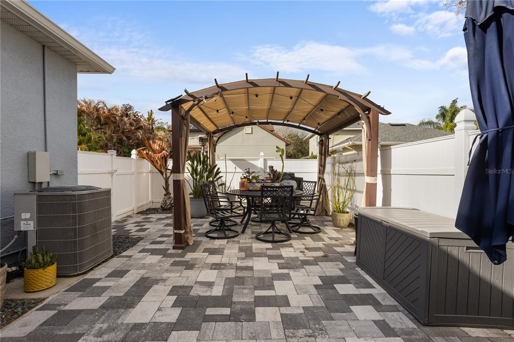 6911 Beargrass Road Harmony, FL 34773 - Photo 37 of 60 a view of a patio with table and chairs with wooden floor and fence