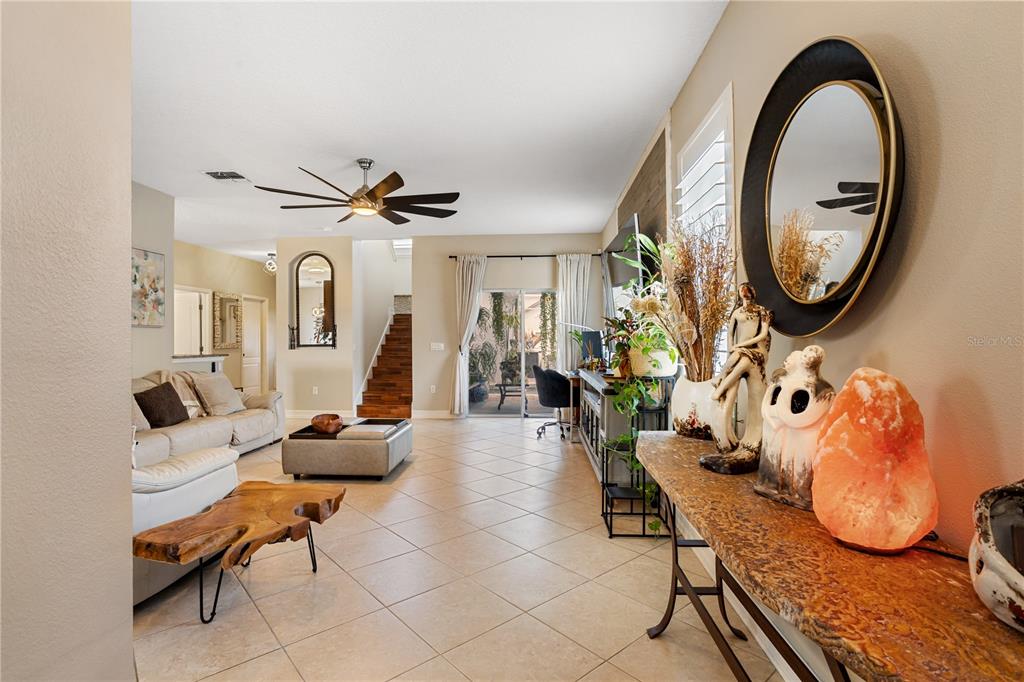 6911 Beargrass Road Harmony, FL 34773 - Photo 6 of 60 a living room with furniture a rug and a chandelier