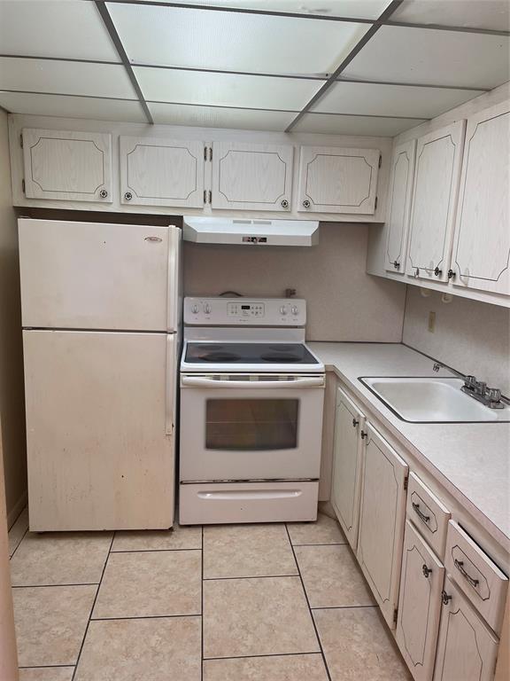387 Tilford R, Unit 387 Deerfield Beach, FL 33442 - Photo 4 of 53 a kitchen with cabinets and white appliances