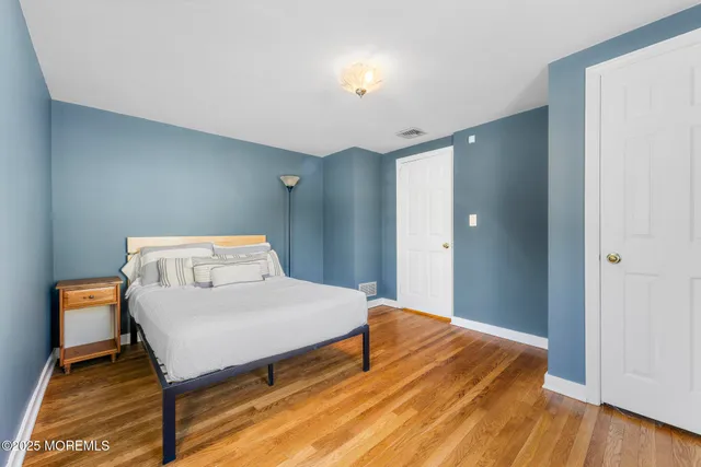 a bedroom with a bed and wooden floor