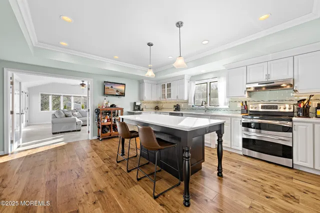 a kitchen with stainless steel appliances granite countertop a stove a sink dishwasher and a refrigerator with wooden floor