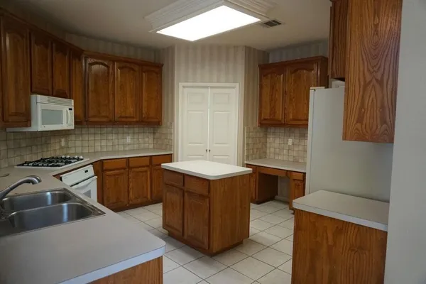 a kitchen with a stove sink and cabinets