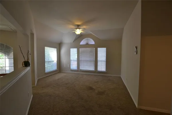 a view of a room with a chandelier fan and a window