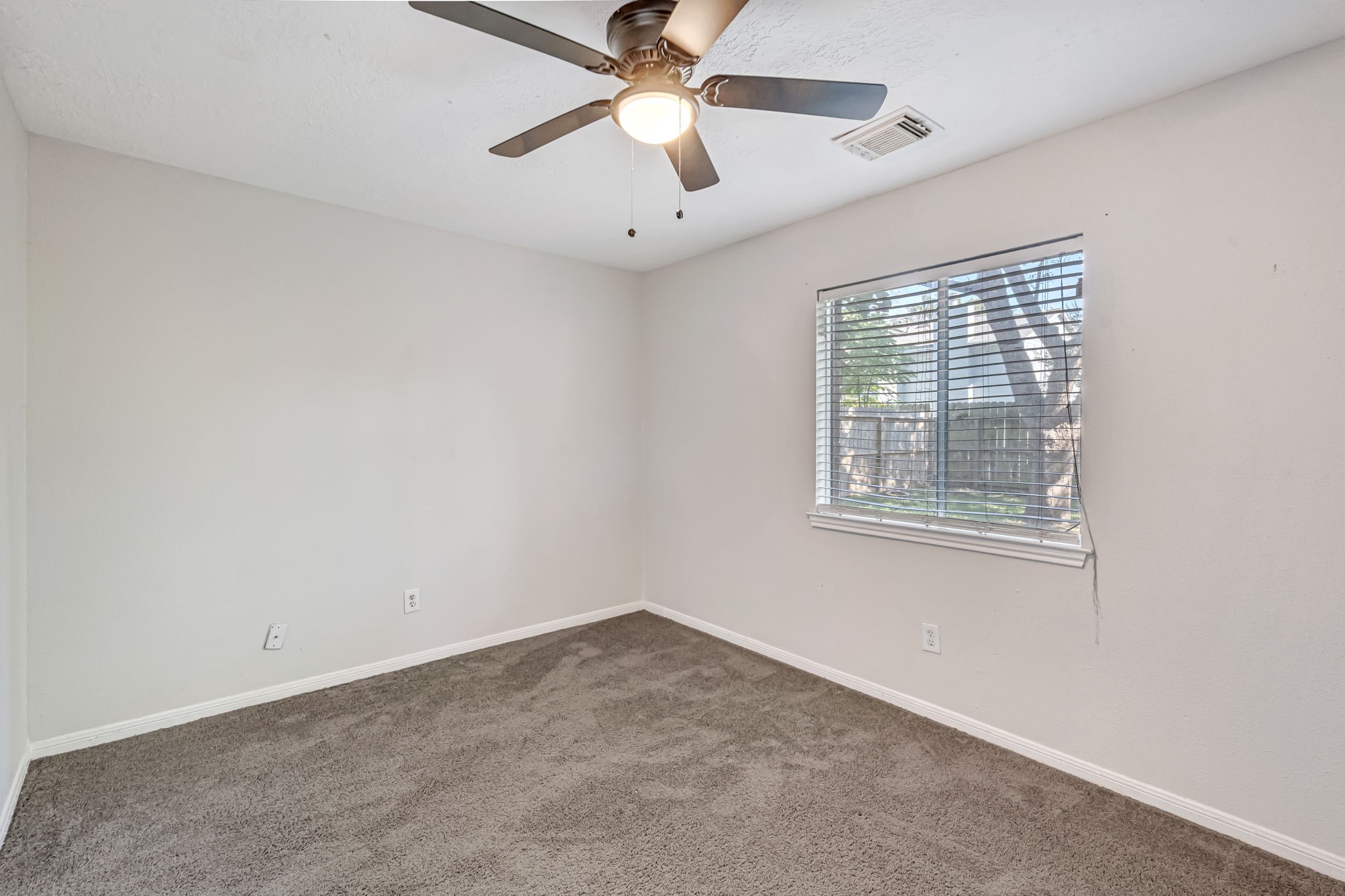 16722 Shrub Oak Drive Humble, TX 77396 - Photo 17 of 30 an empty room with a window and a fan