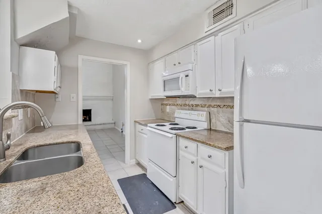 a kitchen that has a sink a stove and a refrigerator