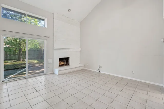 a view of an empty room with window and fire place