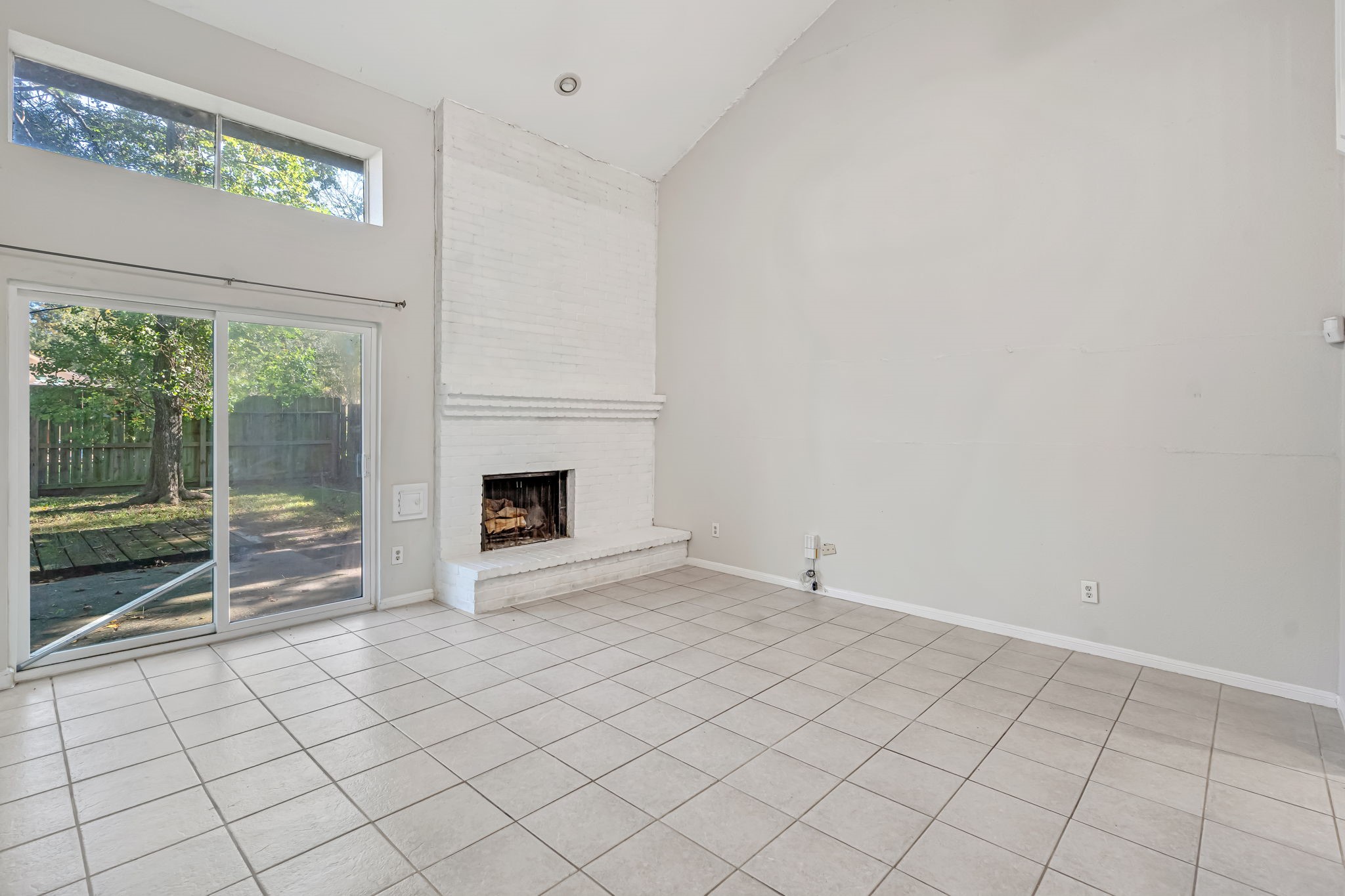 16722 Shrub Oak Drive Humble, TX 77396 - Photo 9 of 30 a view of an empty room with a fireplace and a window