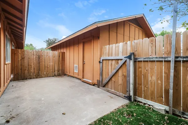 a view of a small house with wooden fence