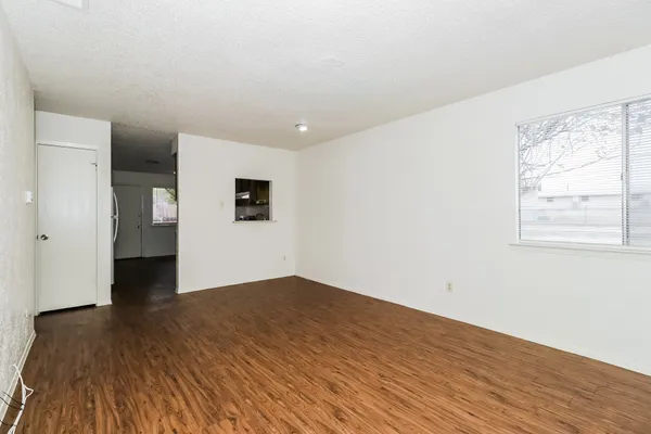 a view of empty room with wooden floor and windows